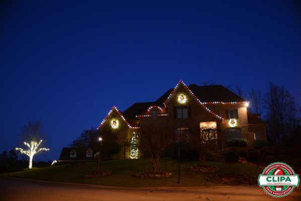 white lights wrapping tree red white holiday lights framing residential home roof